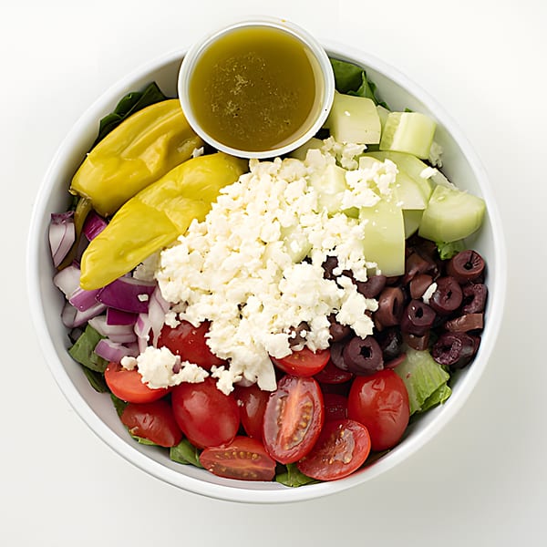 Holy Bowly's Greek salad with feta, olives, tomatoes, cucumbers, peppers, and dressing.